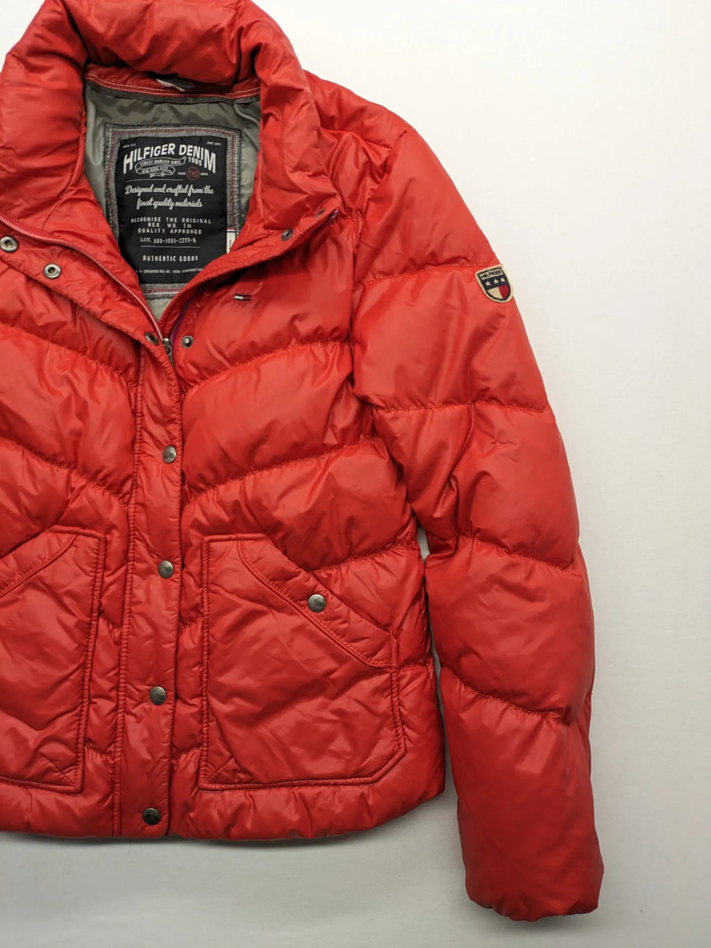 Hilfiger Denim red down jacket with quilted design, stand collar, and zip closure.