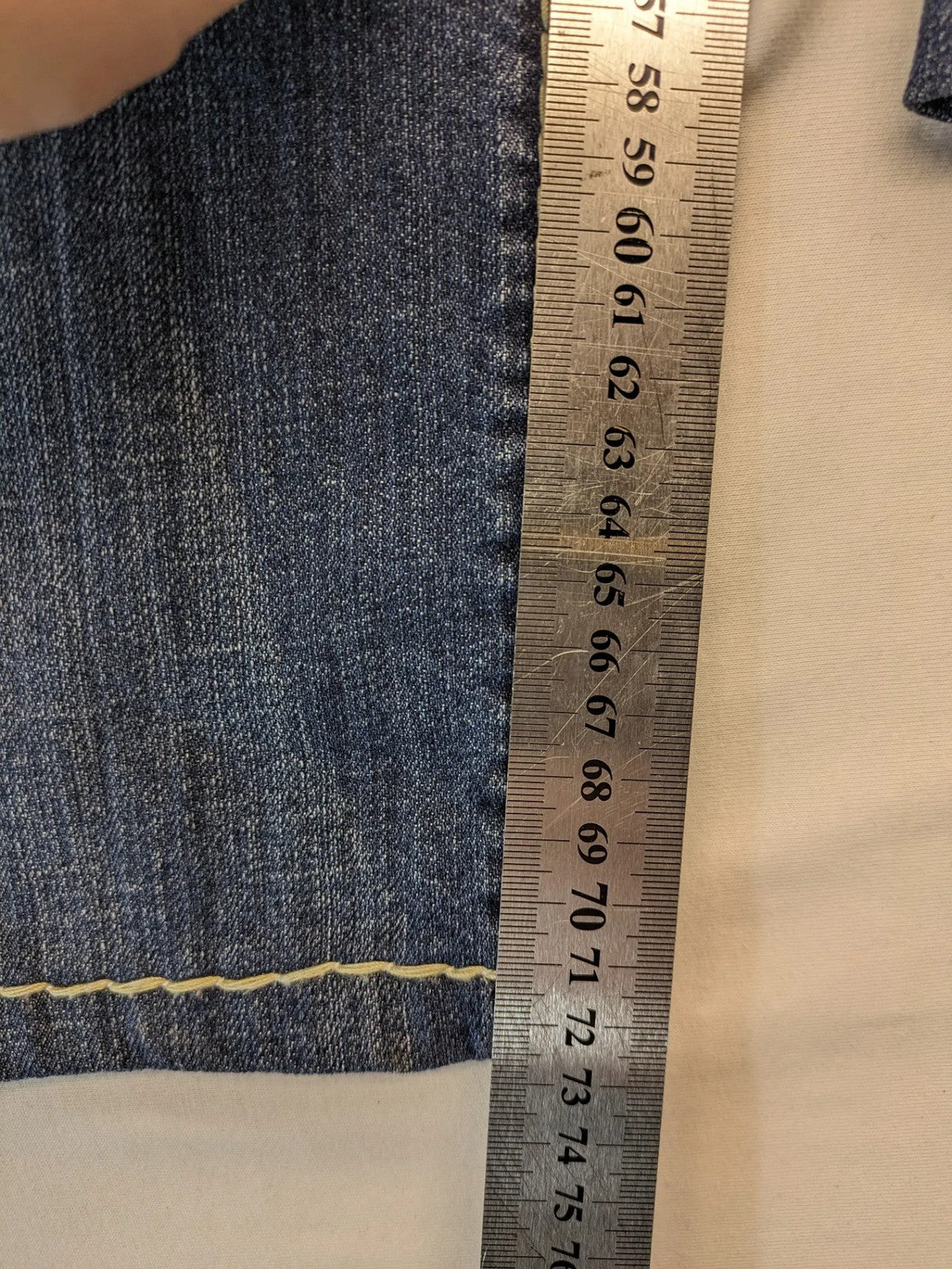 Rhodes blue skinny jeans with decorative studs and intricate embroidery on back pockets.