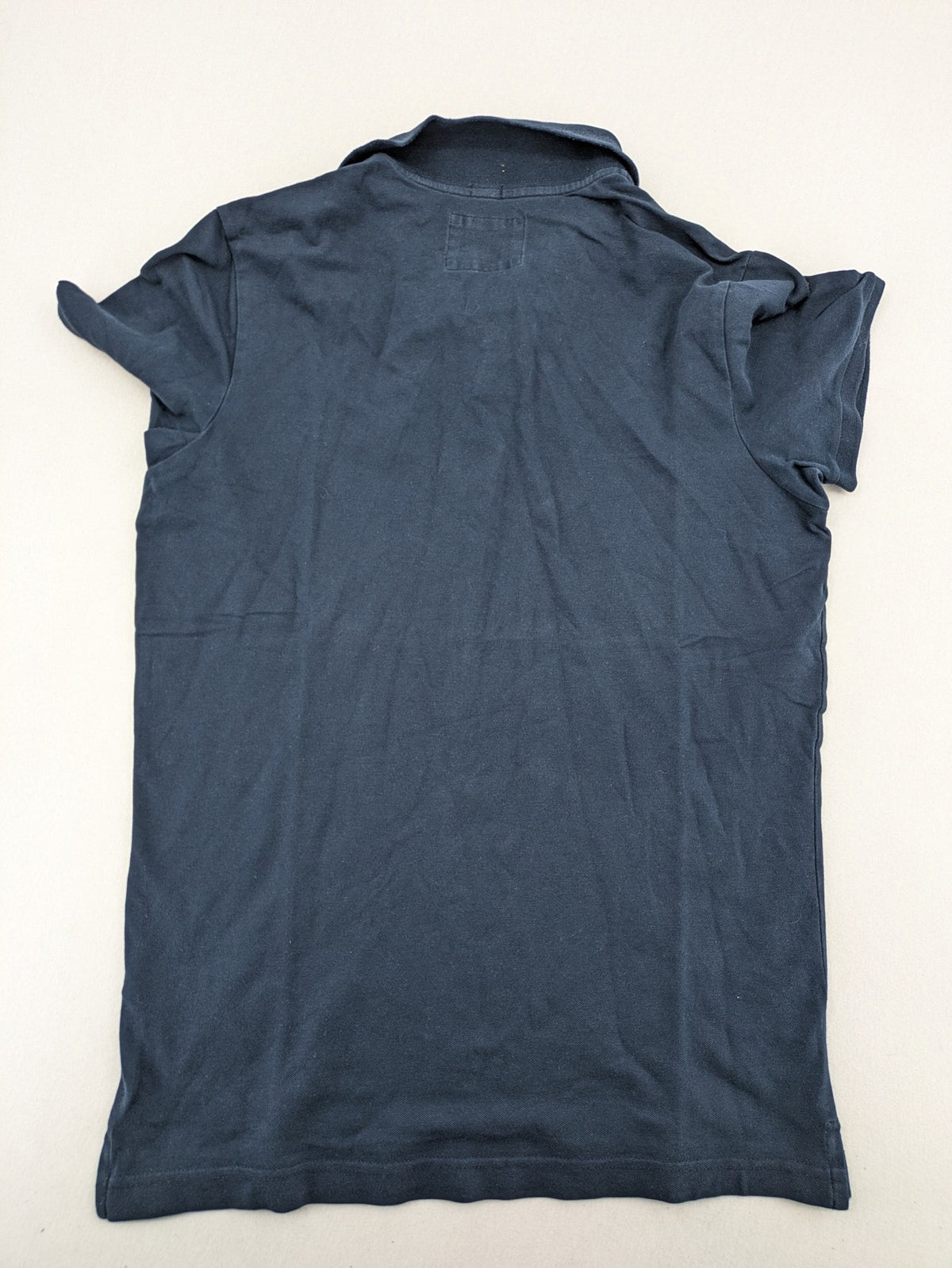 Hollister polo shirt navy blue with embroidered seagull logo and green trim.