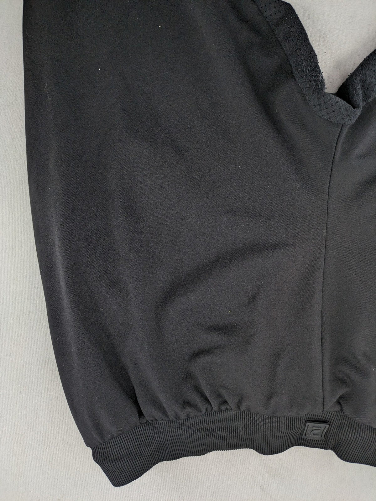 Kalenji black loungewear pants with grey accents and zippered side pockets.