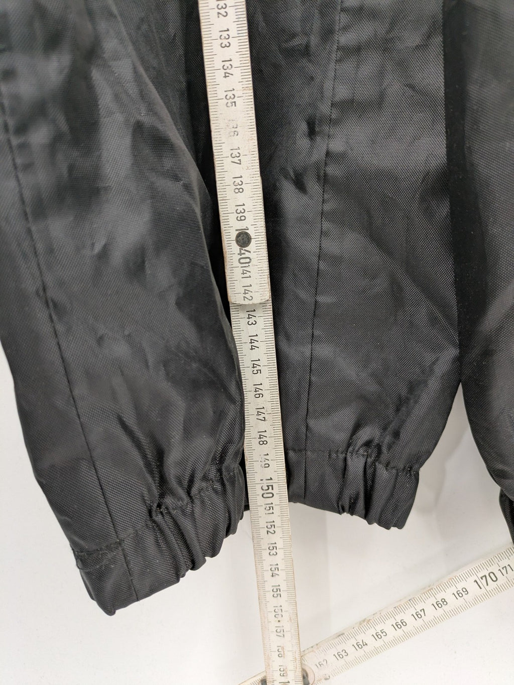 Unitech black rain suit with red reflective stripes and full zipper, size M.