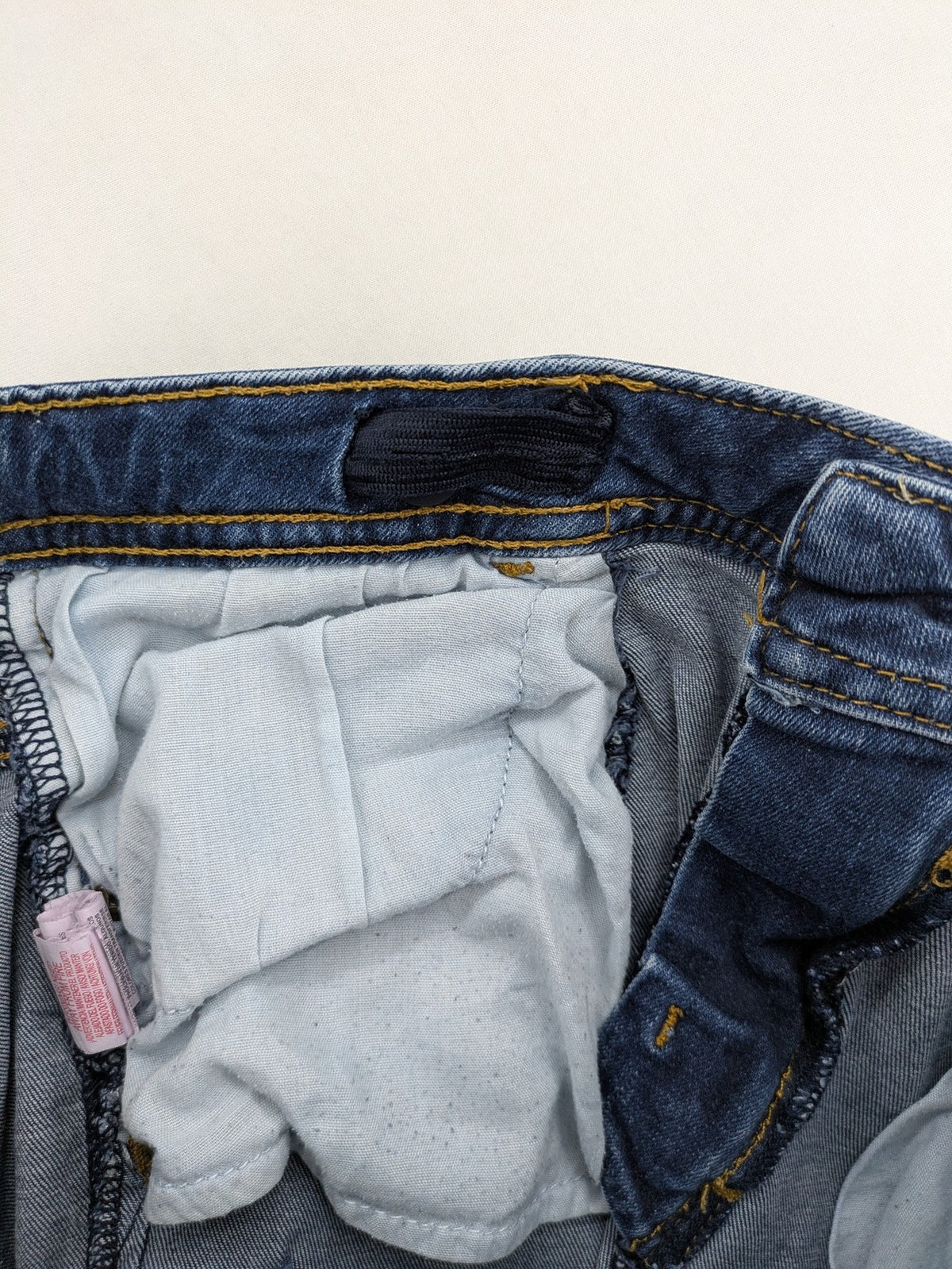 Denim & Co. blue skinny jeans with distressed ripped details and adjustable waistband.