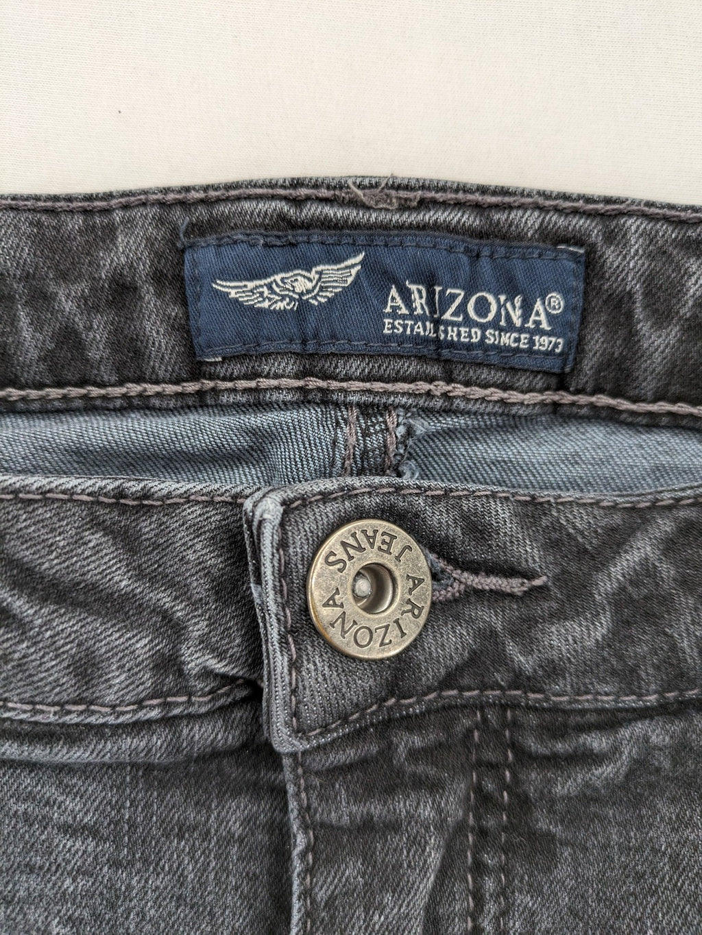 Arizona grey straight jeans with pearl-embellished wing appliqué on back pocket.
