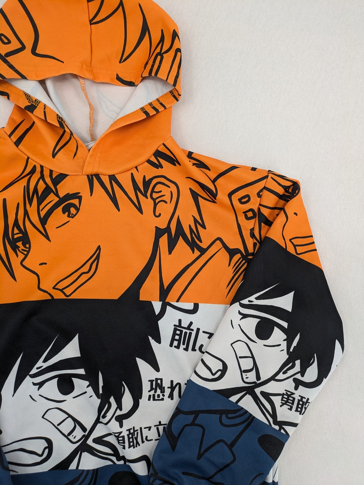 SHEIN orange zip-through hoodie with vibrant anime graphic print and colorblock design.