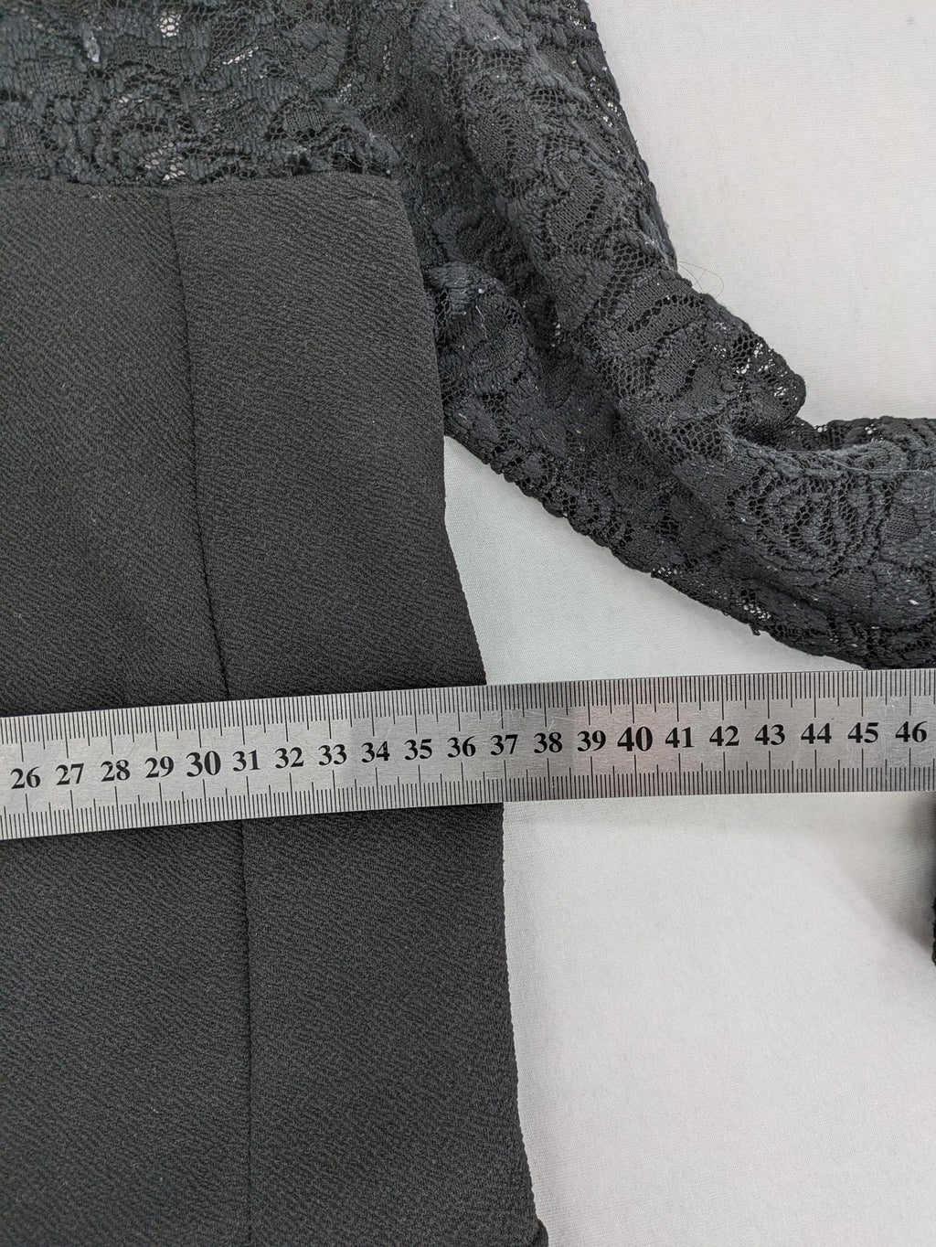 Amisu black peplum top with floral lace sleeves and delicate lace trim.