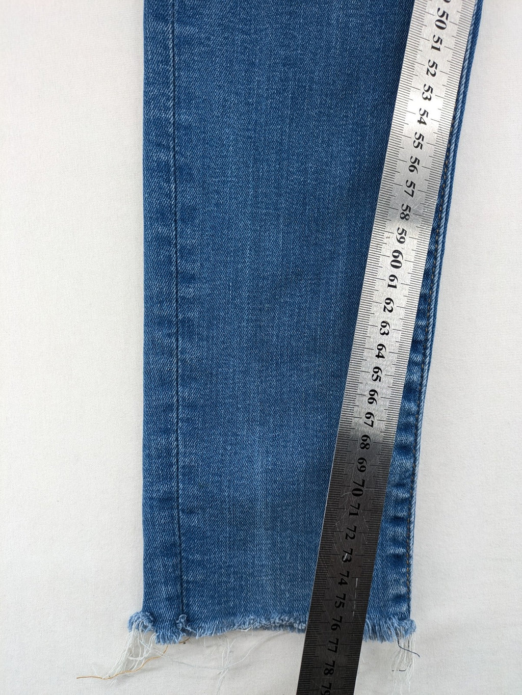 Levi's blue skinny jeans with raw hem, classic five-pocket design, and zip fly.