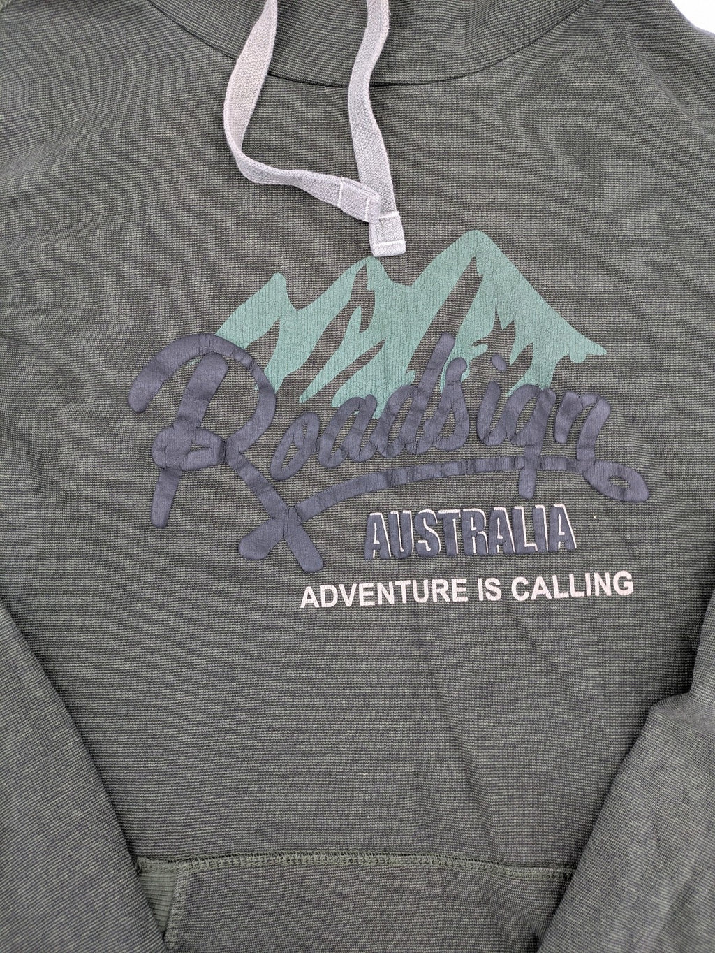 Roadsign Australia green hoodie with mountain graphic print and logo patch on sleeve.