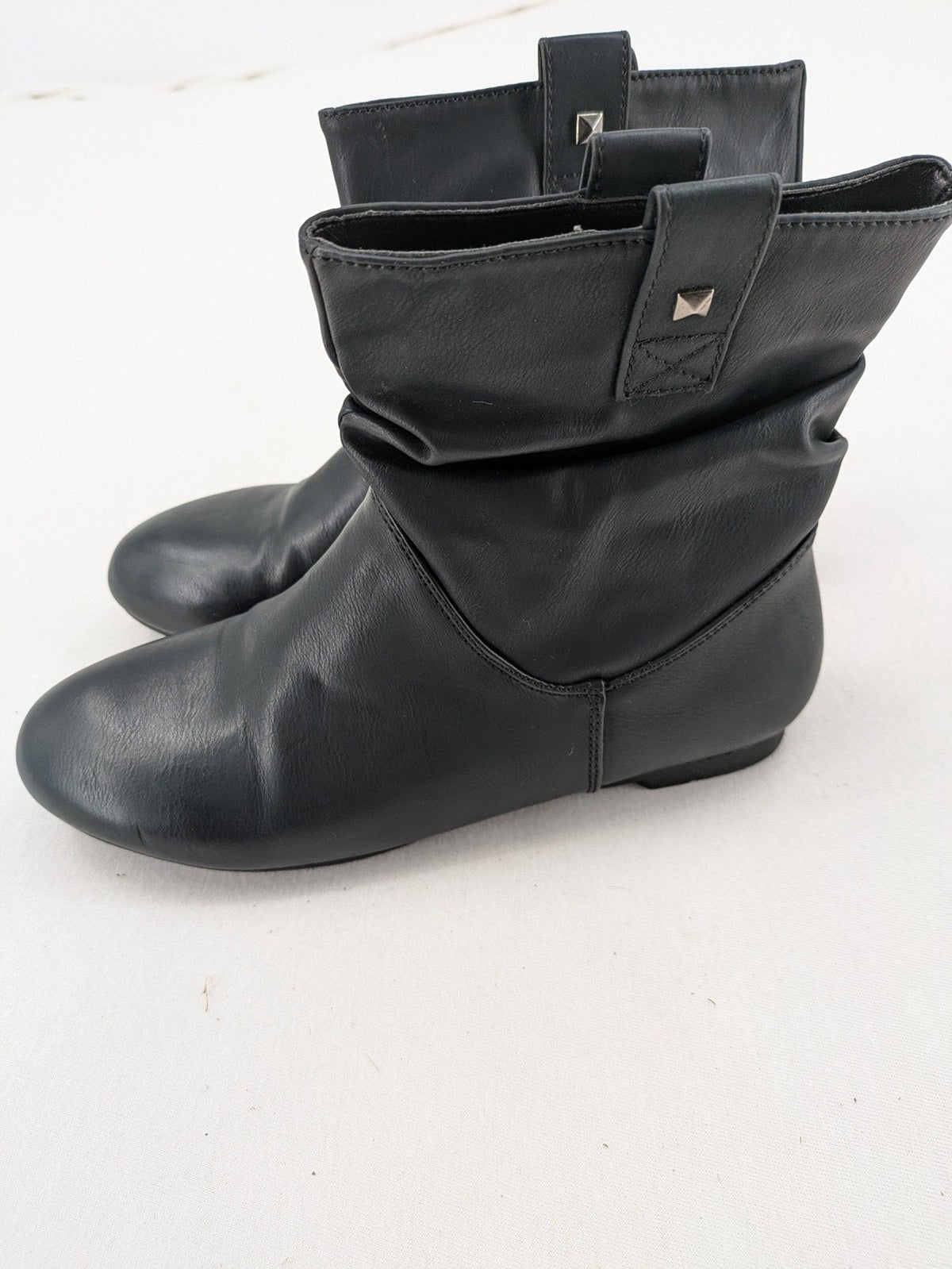 DAF black booties with decorative strap and studded details, made of faux leather.