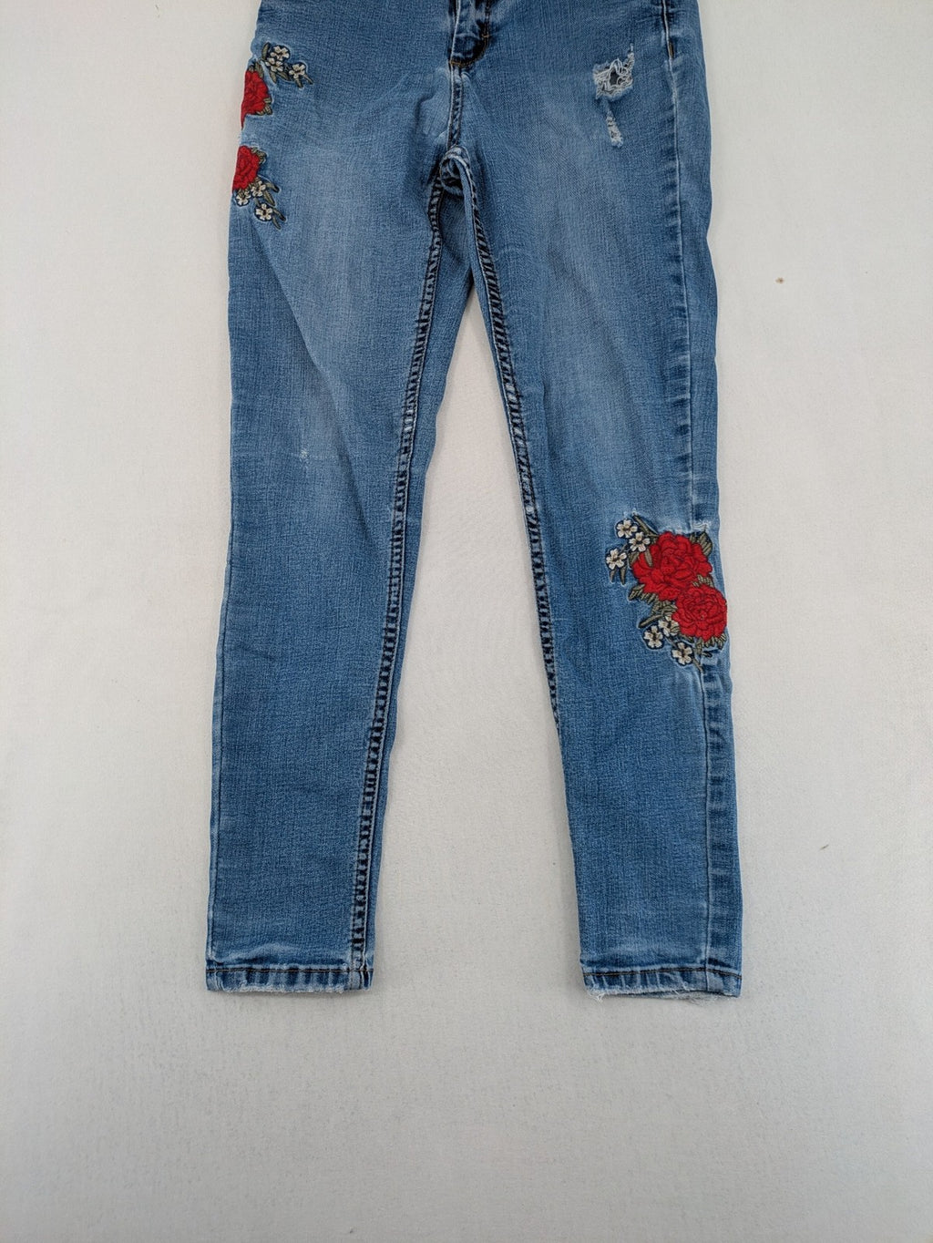 Jennyfer pink skinny jeans with distressed details and red rose embroidery on hips and knees.