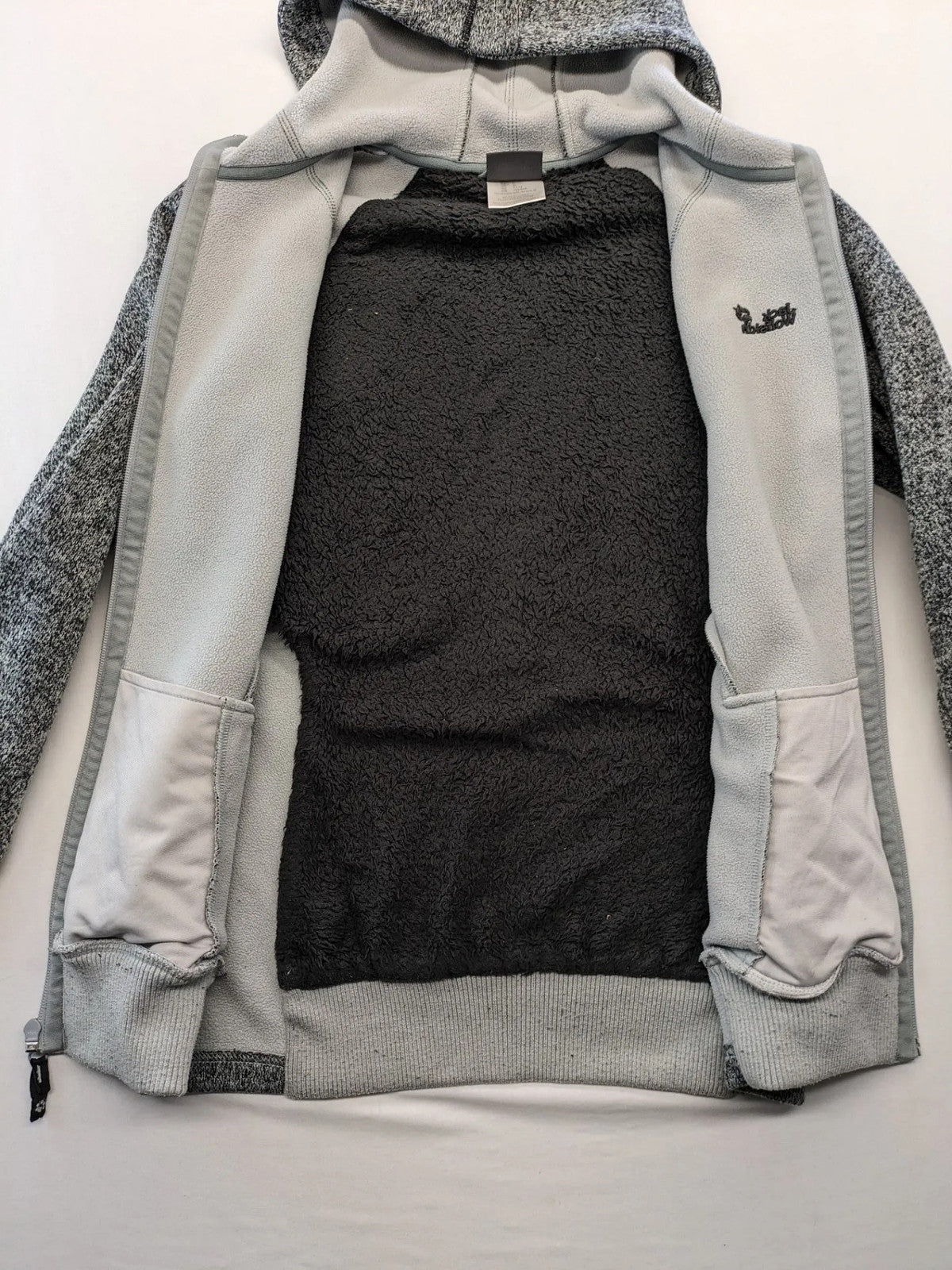 Jack Wolfskin grey fleece jacket with logo detailing and two front pockets.