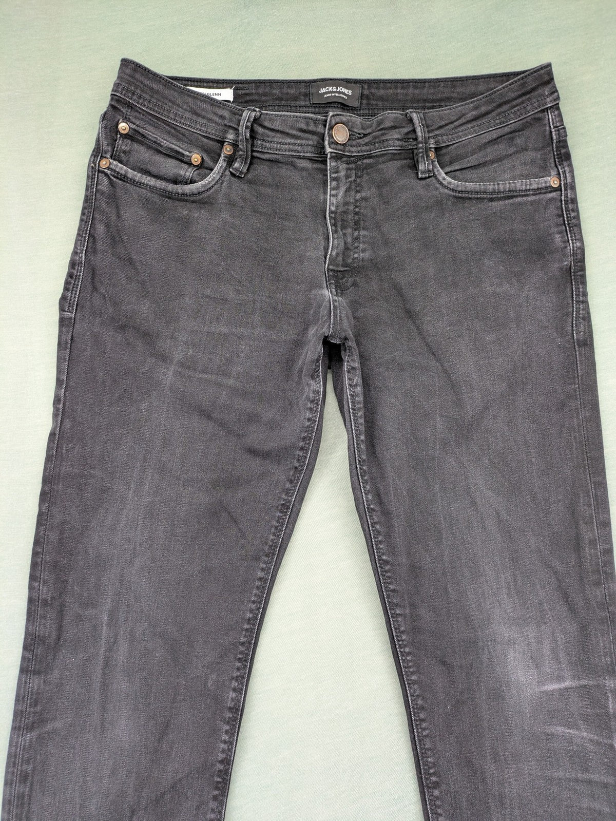 Jack & Jones black slim fit jeans faded wash stretch denim with logo detail.