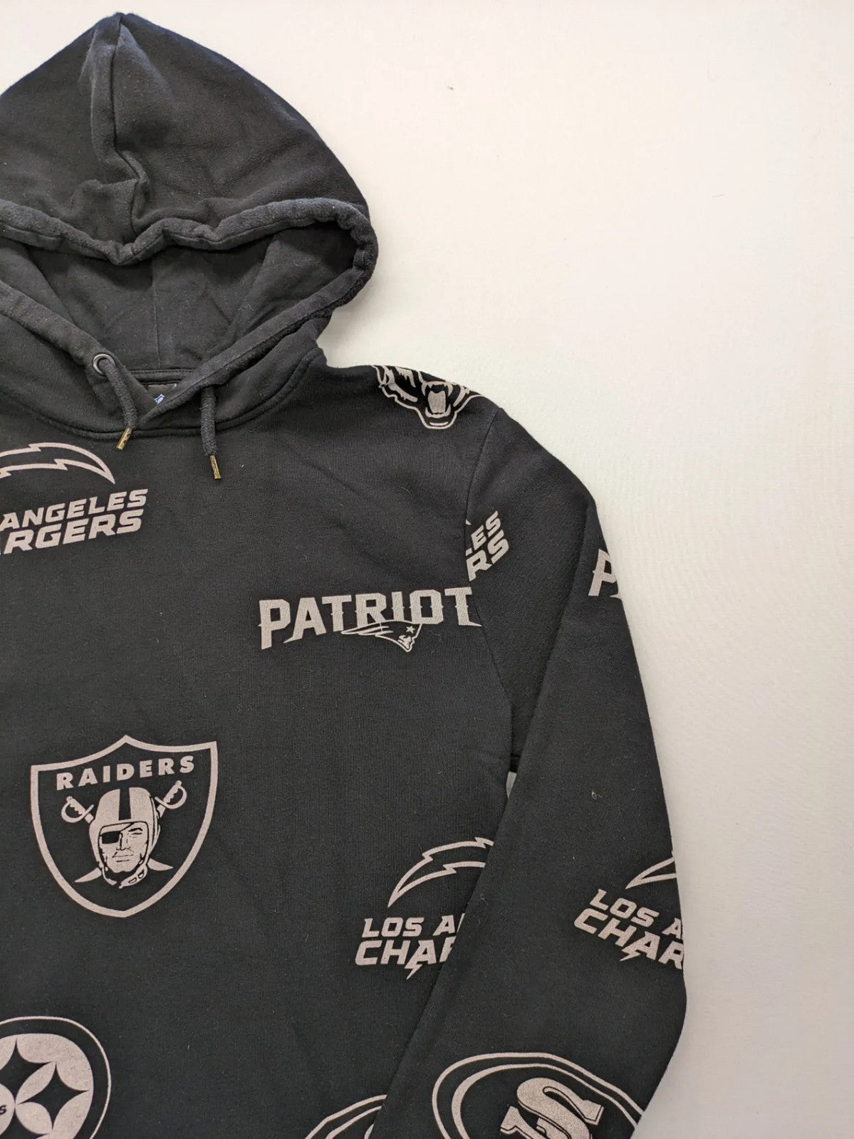NFL black hoodie all-over team logo print, adjustable hood, cotton blend material.