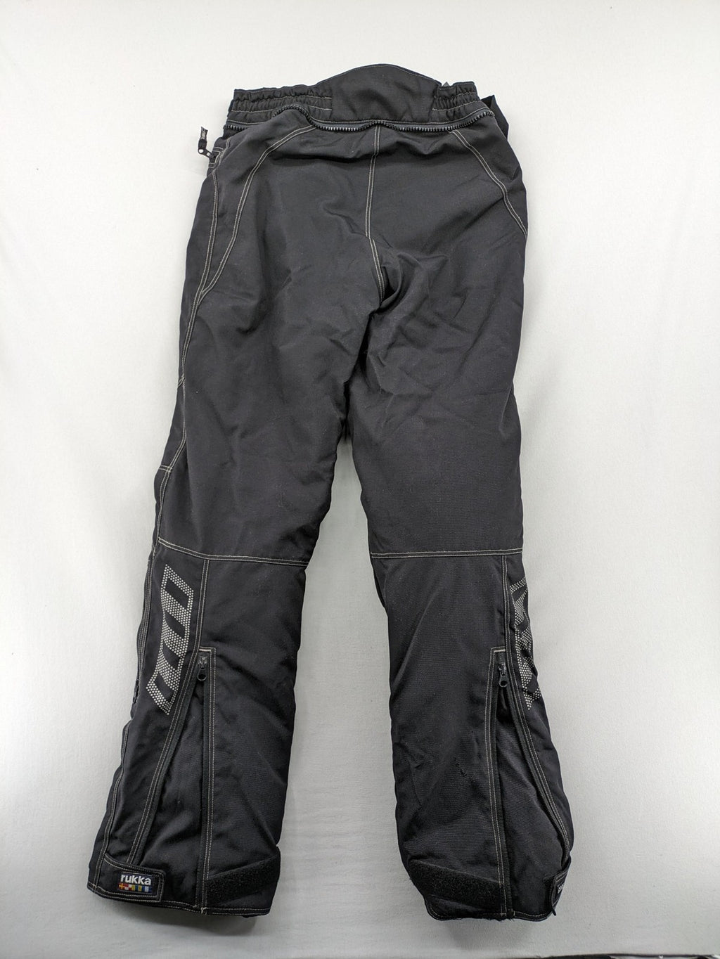 Rukka black motorcycle chaps with grey accents and CE knee protectors, made from durable Cordura.