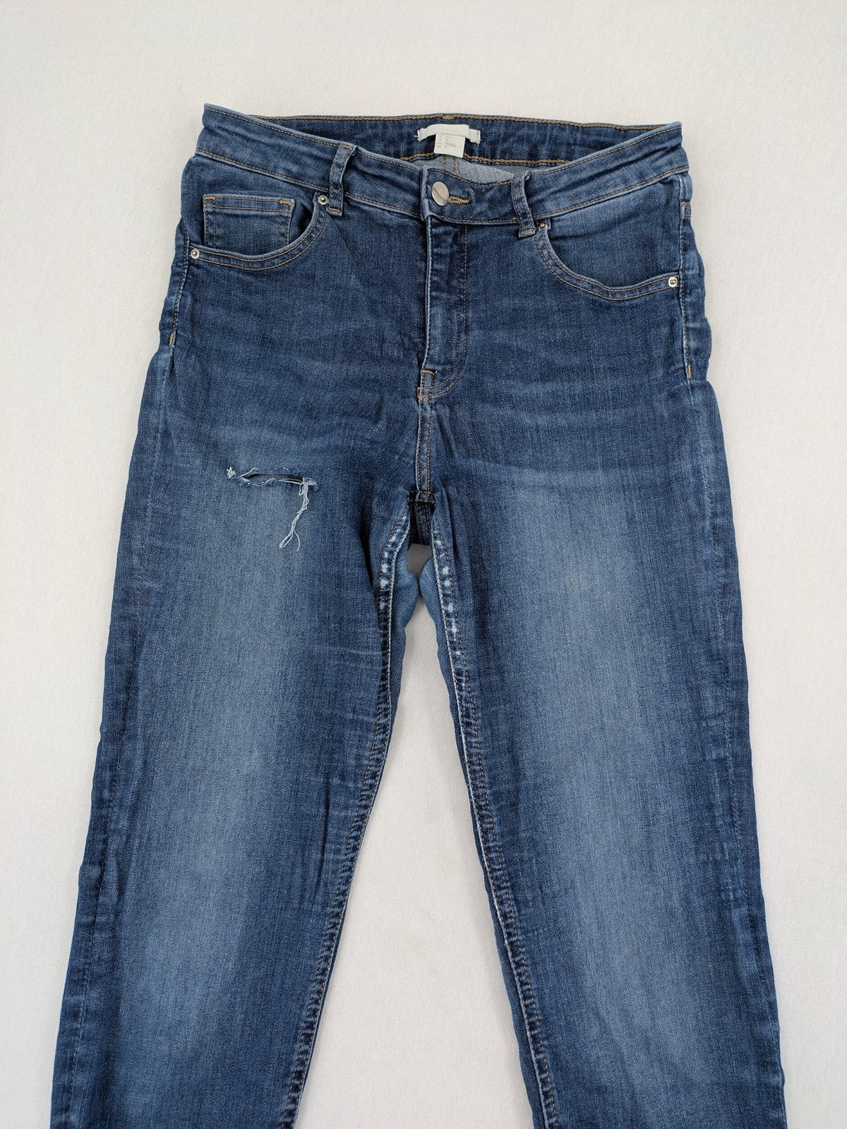 H&M blue skinny jeans with distressed details and comfortable stretch denim material.