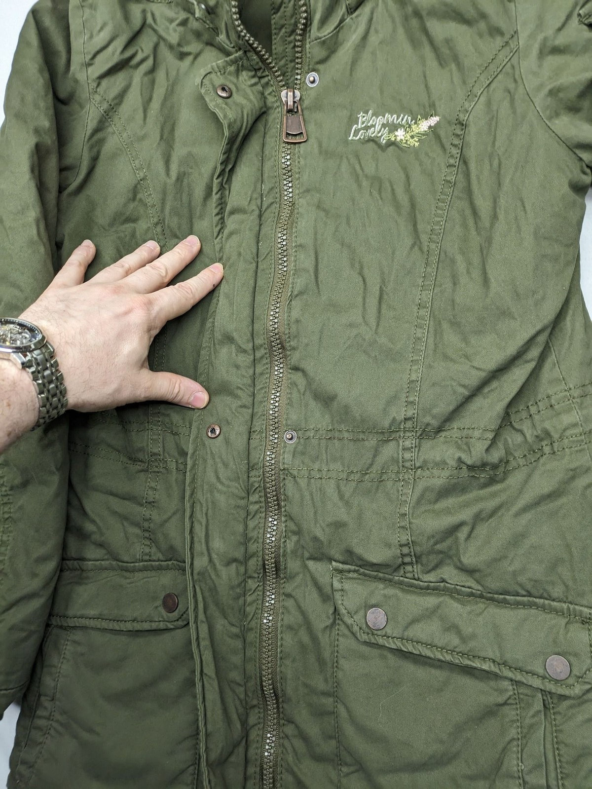 Vp Fashion khaki parka coat with "Bloomin' Lovely" floral embroidery and quilted lining.