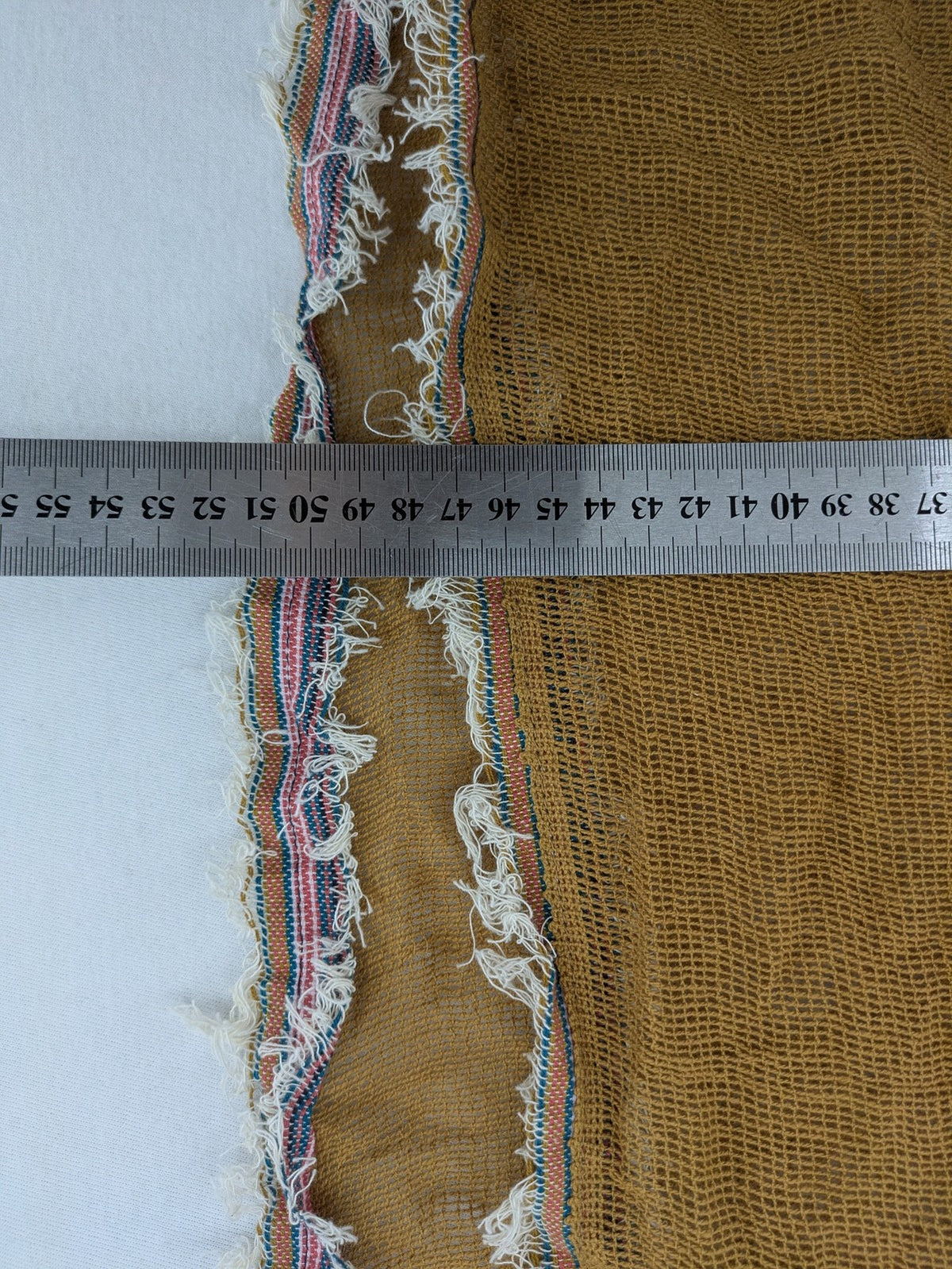 Romano multi scarf ocker with multicolored striped border and fringed edges.