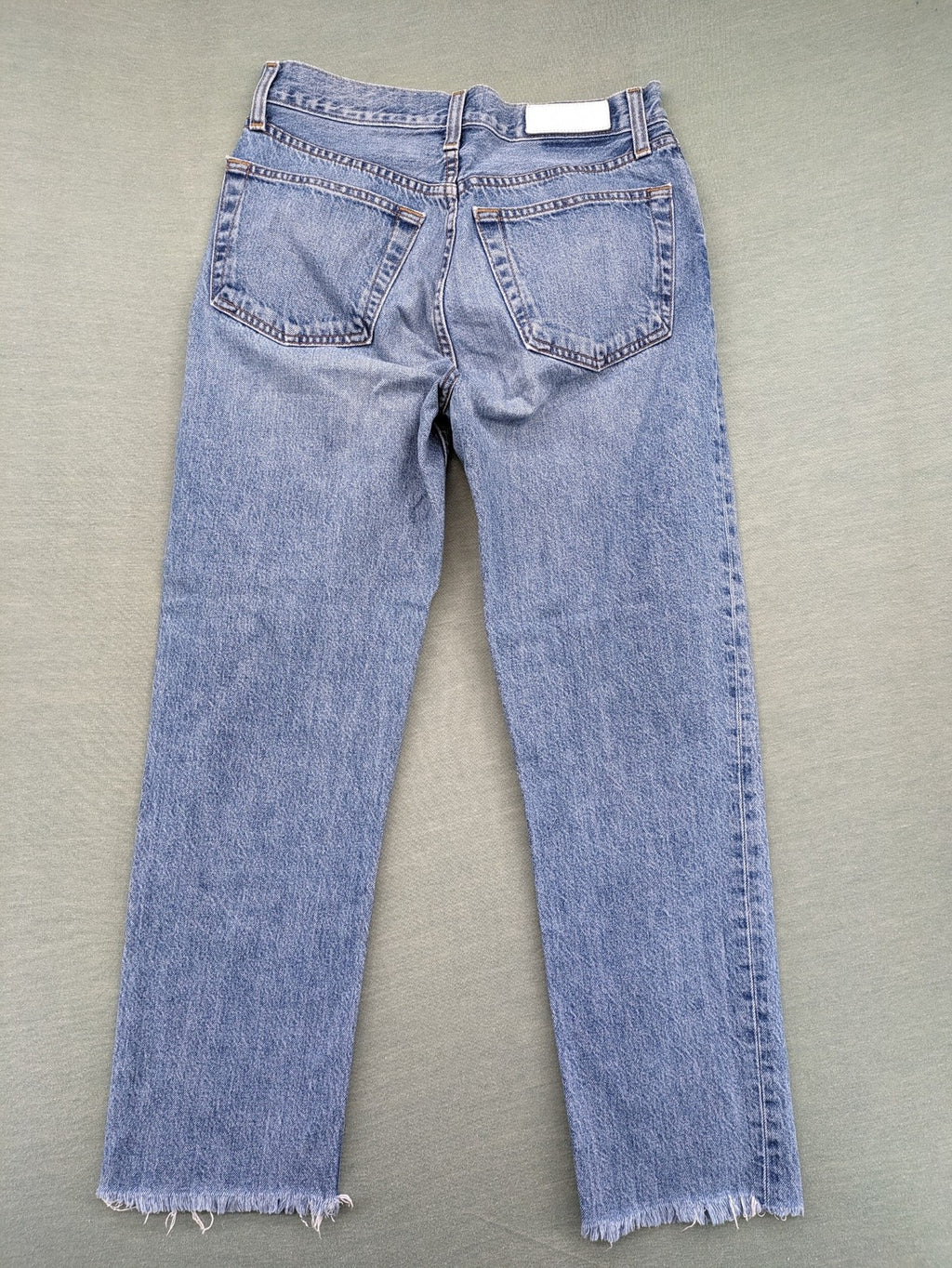 Re/Done blue straight jeans high rise with button fly and raw hem detail.