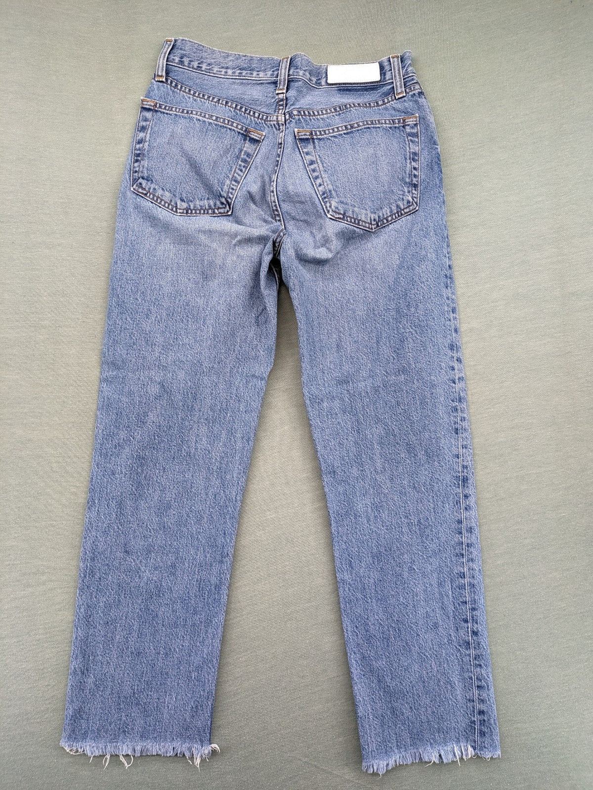 Re/Done blue straight jeans high rise with button fly and raw hem detail.