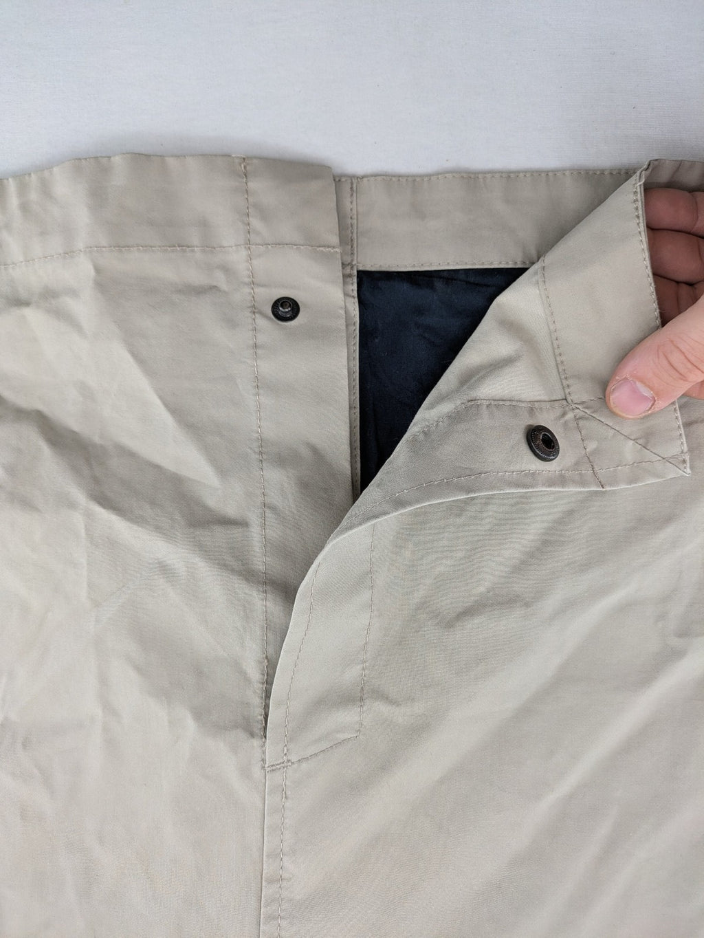 ReSET beige coat with contrasting dark blue lining and classic design details.