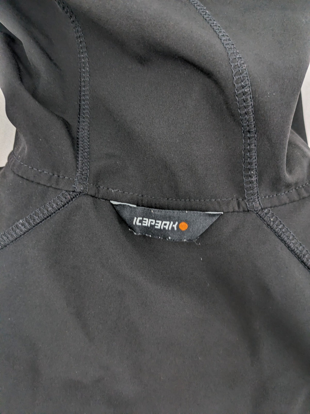 Icepeak black softshell jacket with fleece lining, adjustable hood, and zippered pockets.