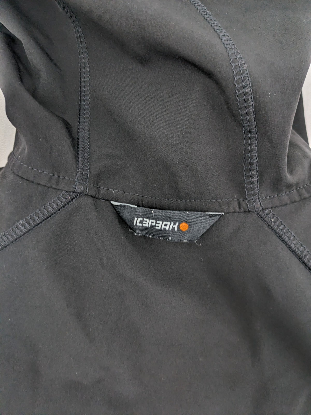Icepeak black softshell jacket with fleece lining, adjustable hood, and zippered pockets.
