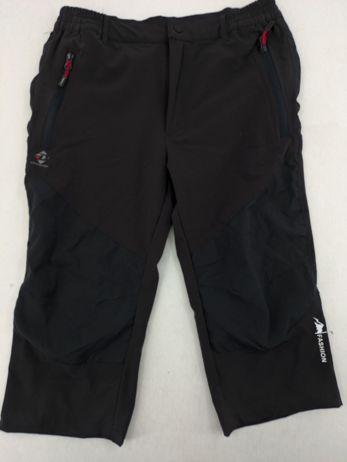 Outdoor black capri pants with elastic waistband and multiple zippered pockets.