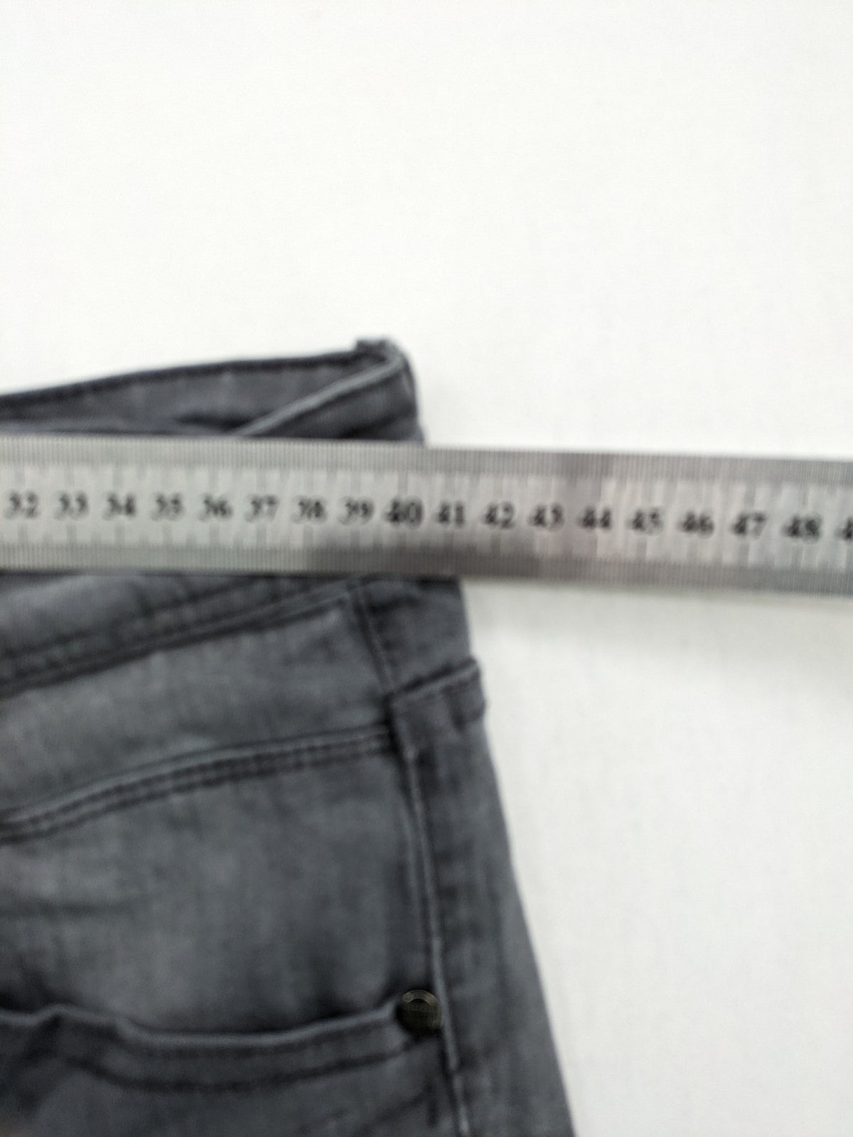 Born Rich grey slim fit jeans with button fly and washed denim texture.