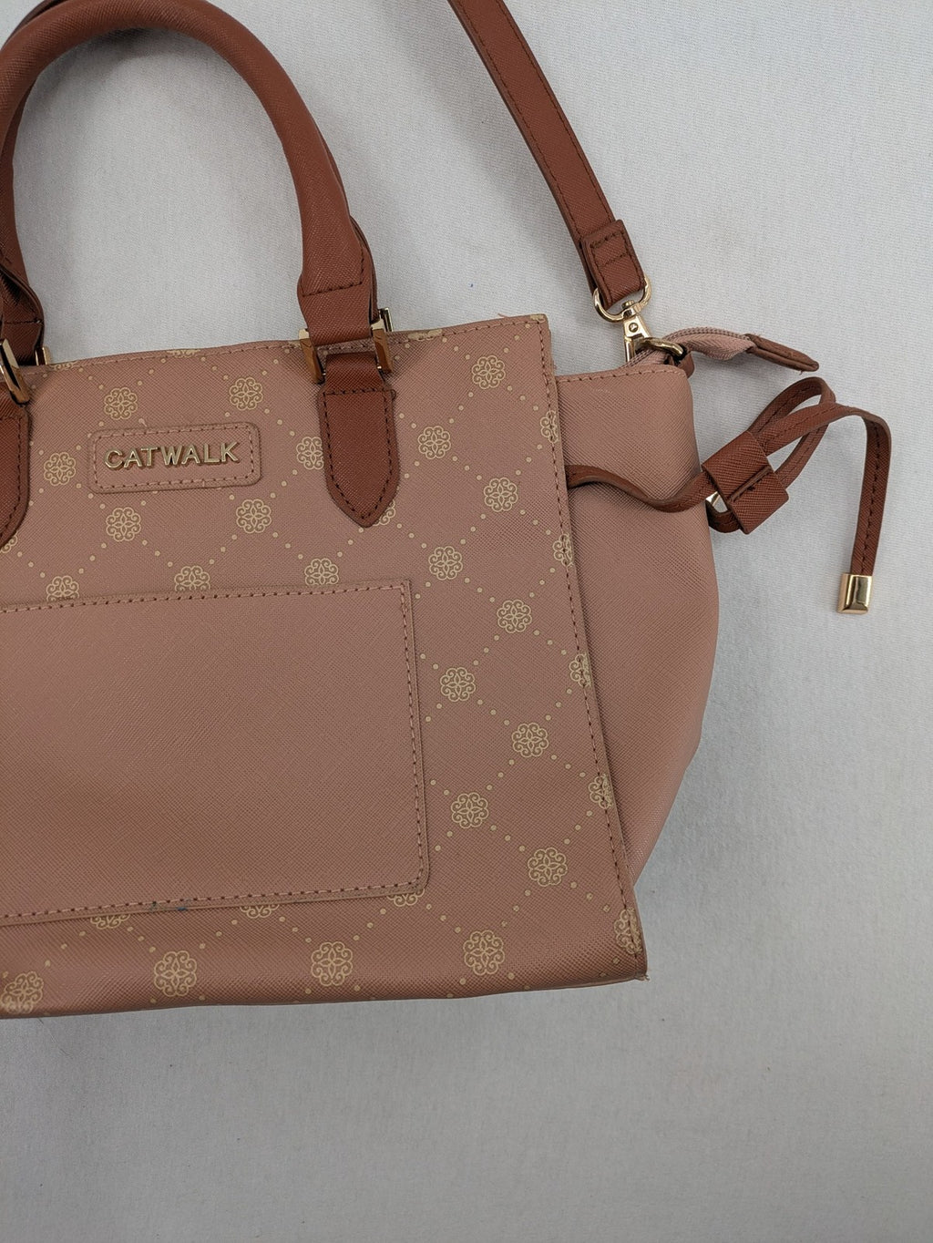 Catwalk gold handbag with pink and brown monogram pattern, adjustable shoulder strap.