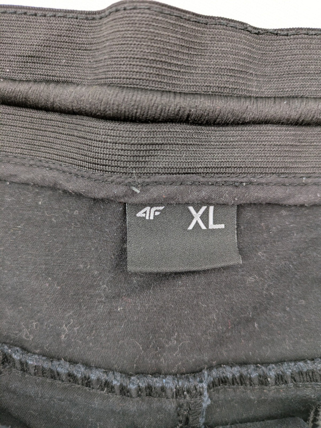 4F black cargo pants with reinforced knees, made from cotton-stretch material.