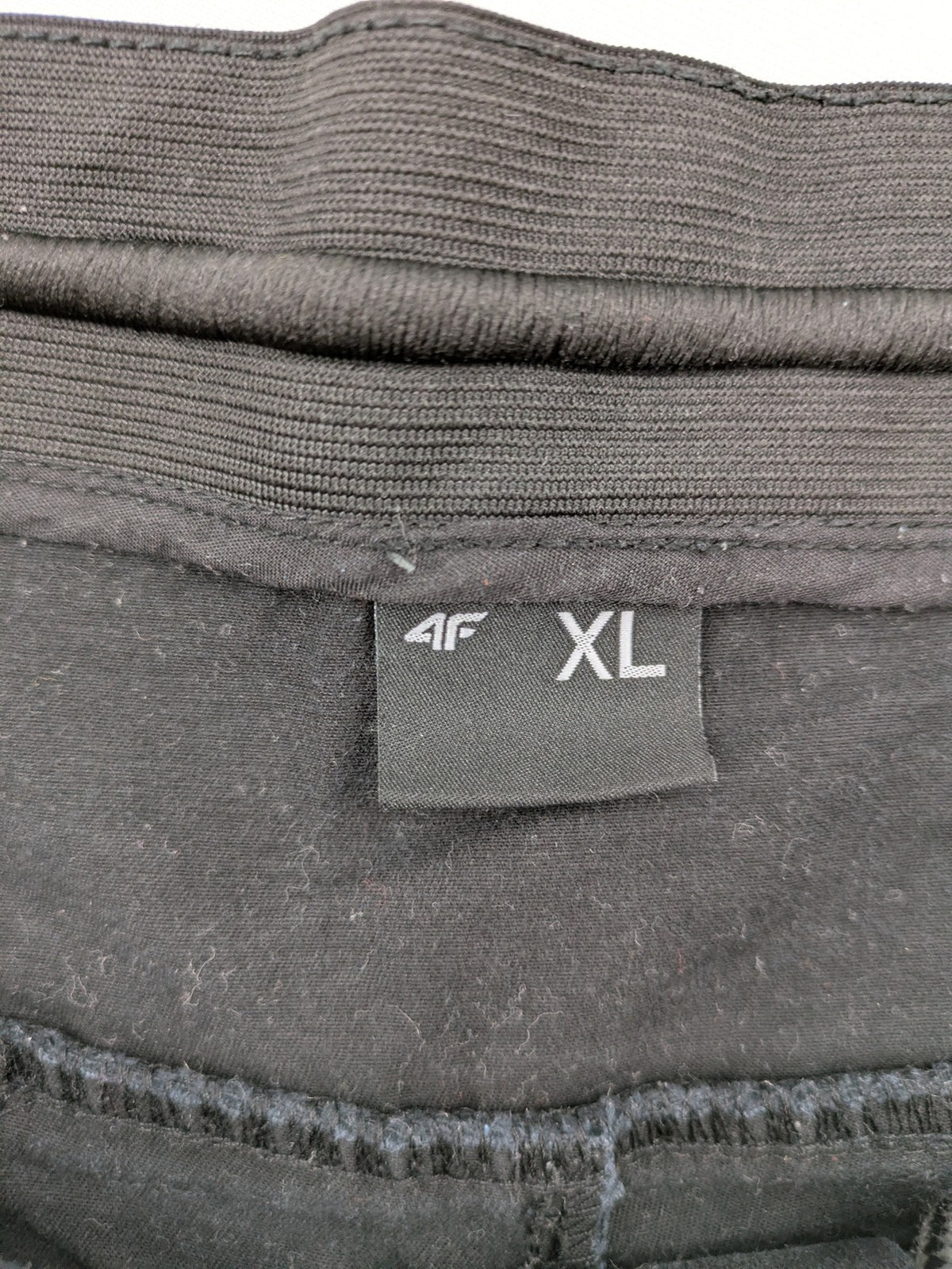 4F black cargo pants with reinforced knees, made from cotton-stretch material.
