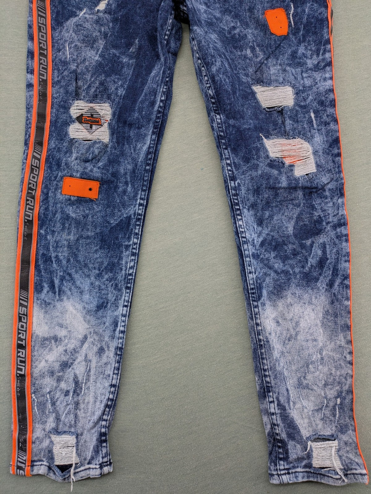Stark straight jeans multi distressed acid wash with orange patches and side stripes.