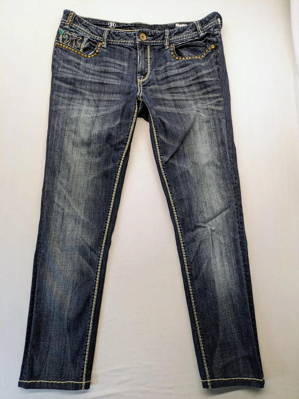 Rhodes blue skinny jeans with decorative studs and intricate embroidery on back pockets.