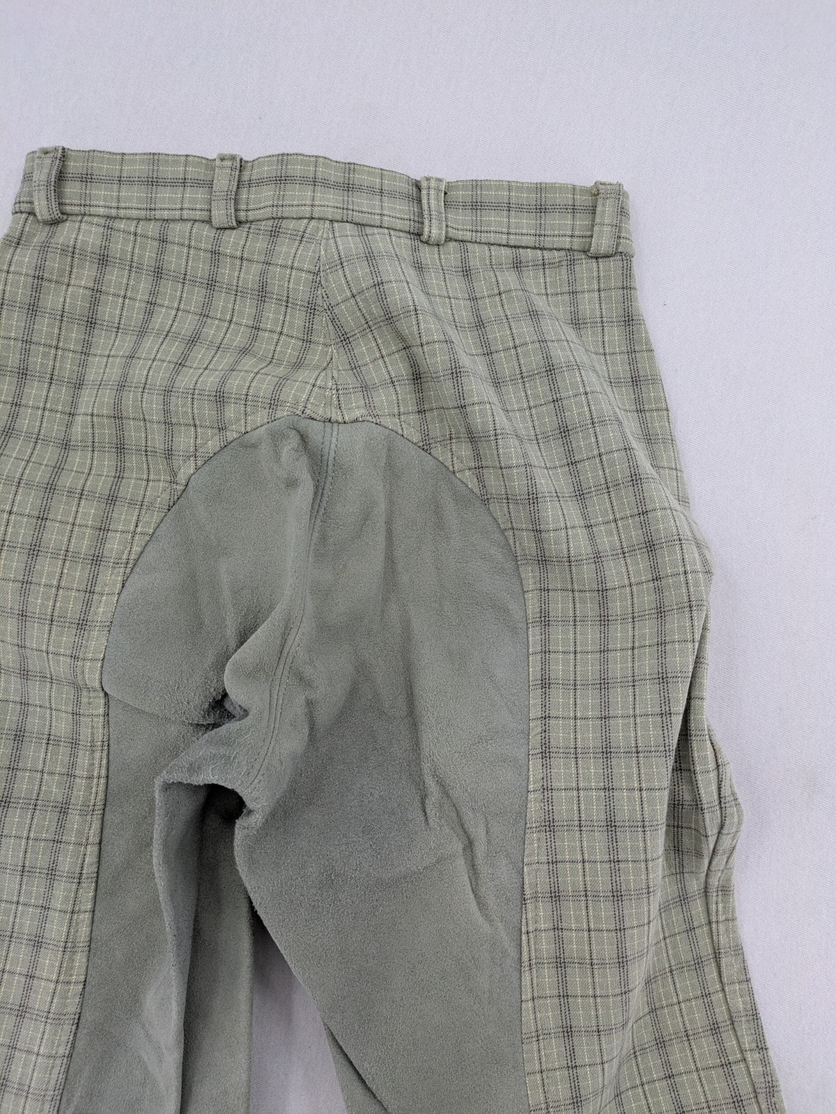 Jodhpur beige and grey riding pants with green check pattern and knee patches.
