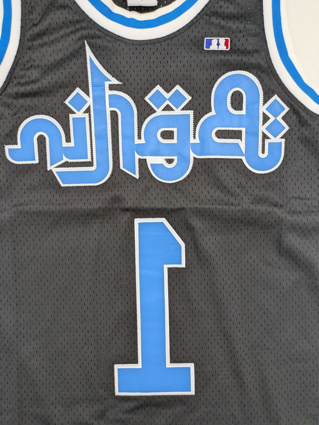 Friends With Money blue basketball jersey black mesh with stylized graphic and number "1