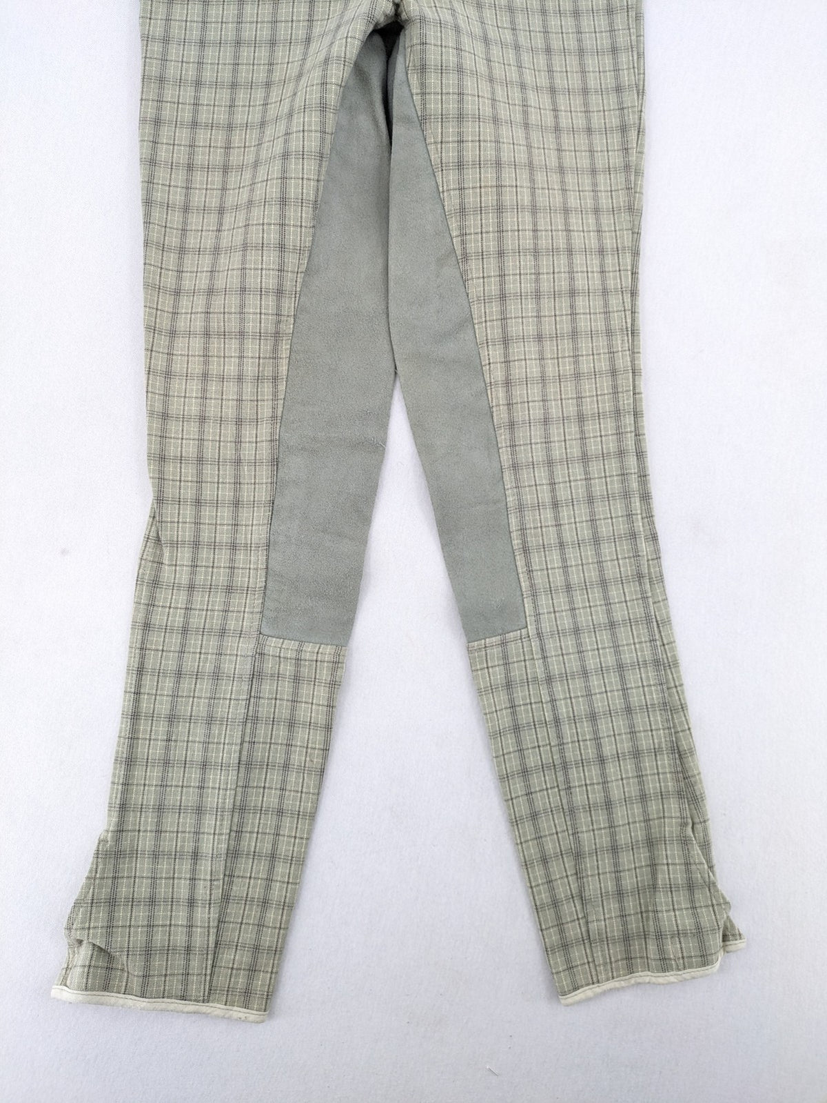 Jodhpur beige and grey riding pants with green check pattern and knee patches.