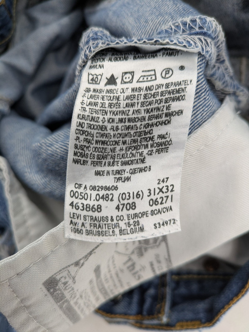 Levi's blue straight jeans with button-fly and distressed knee rips.