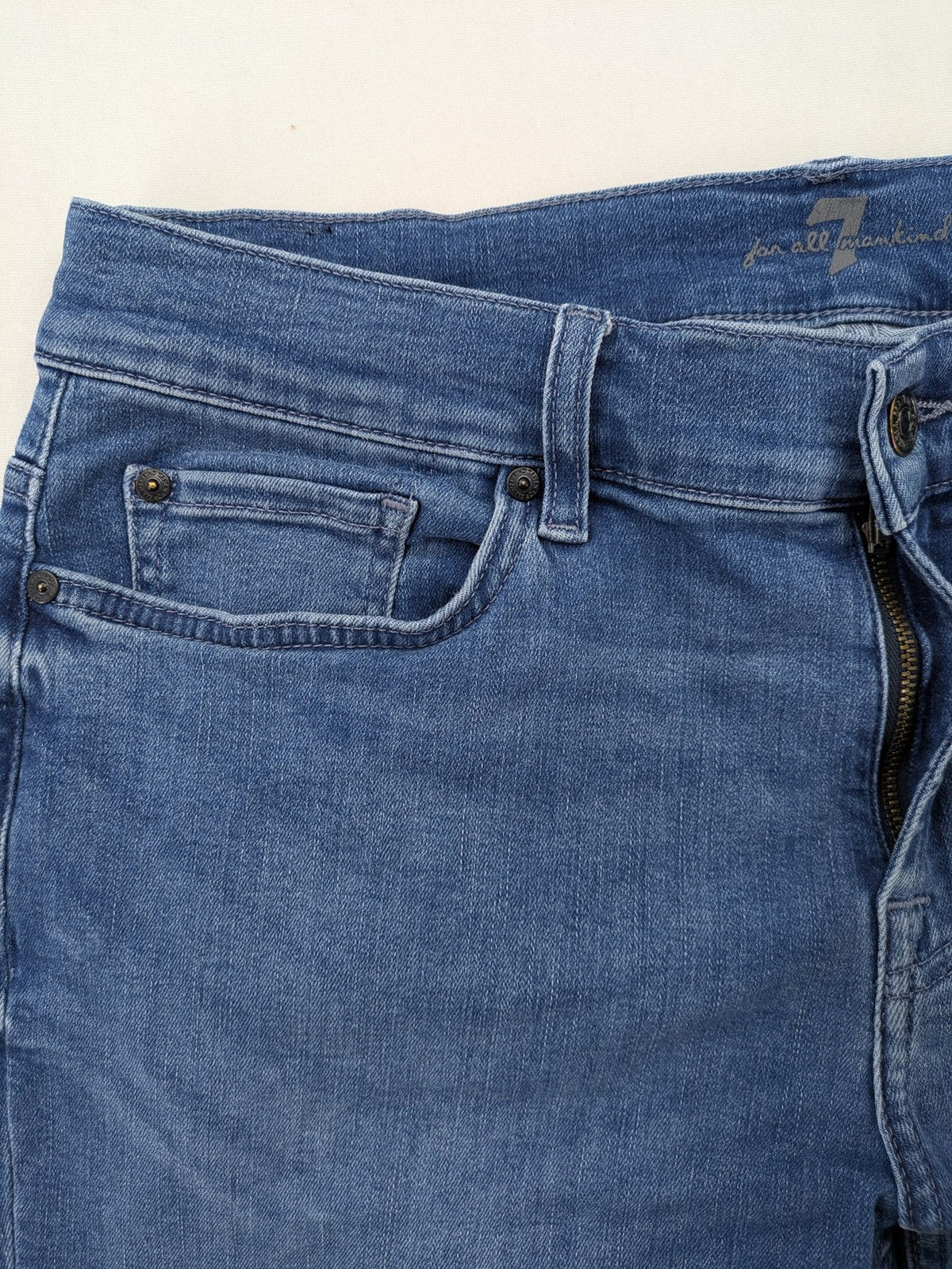 7 For All Mankind blue straight jeans with 5-pocket design and logo on back pocket.