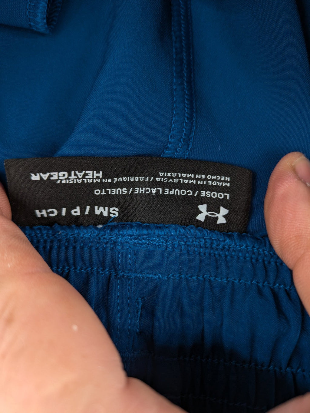 Under Armour blue HeatGear joggers with black accents and zippered cargo pockets.