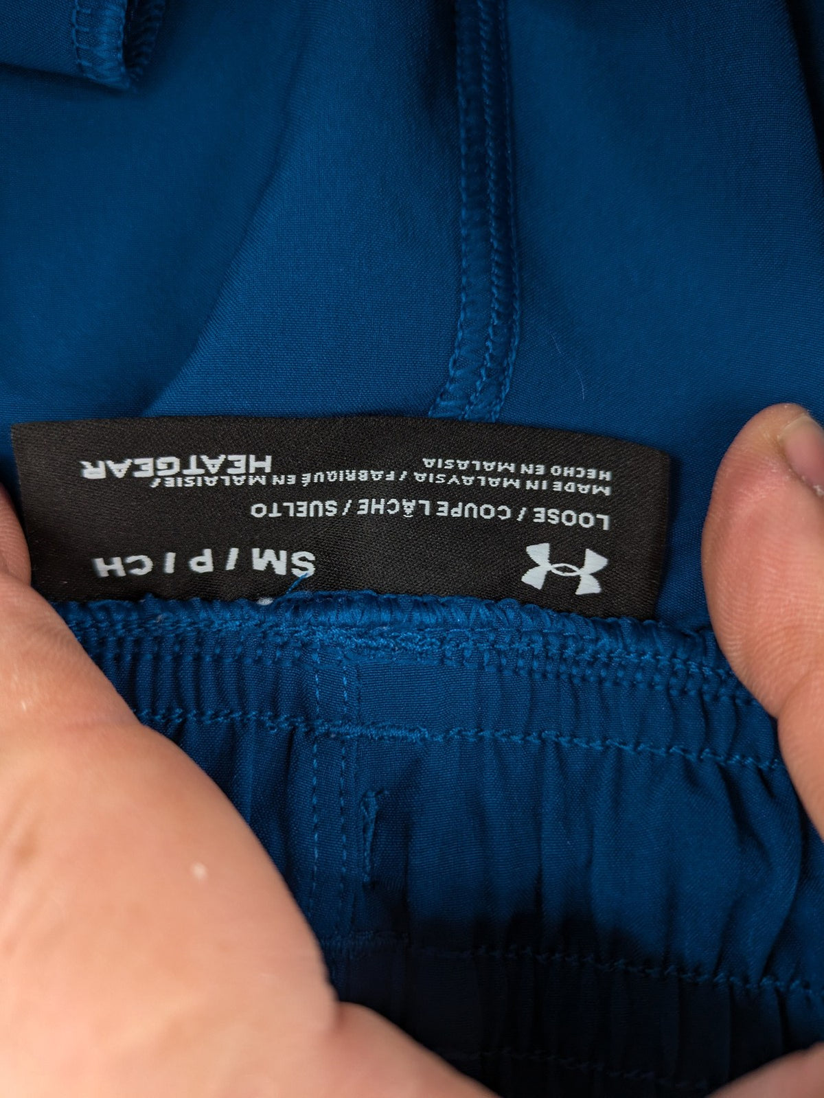 Under Armour blue HeatGear joggers with black accents and zippered cargo pockets.