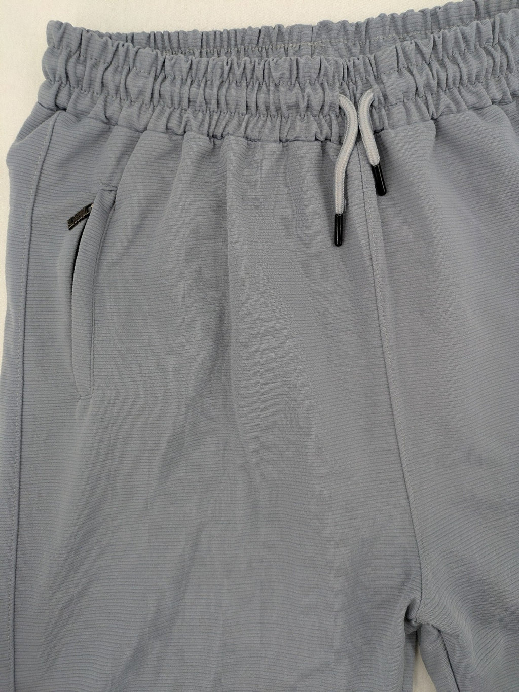 Nike grey shorts with Dri-FIT technology, elastic waistband, and zippered pockets.