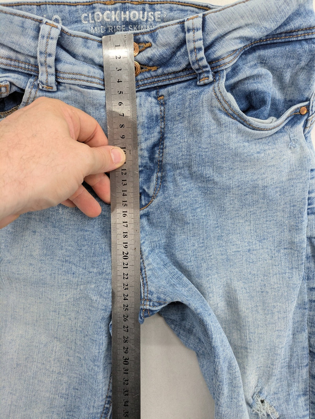 Clockhouse blue skinny jeans with distressed details and frayed hem, mid-rise fit.