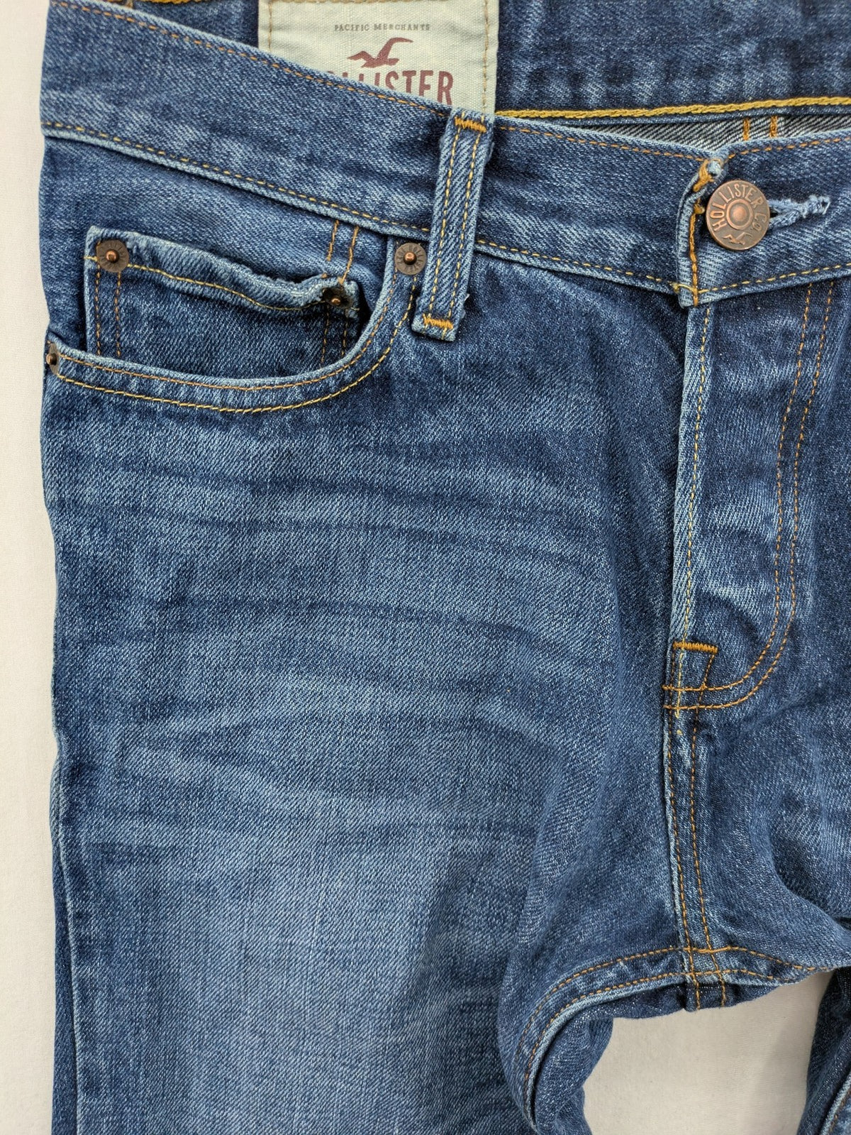 Hollister blue super skinny jeans medium wash button fly with faded details.