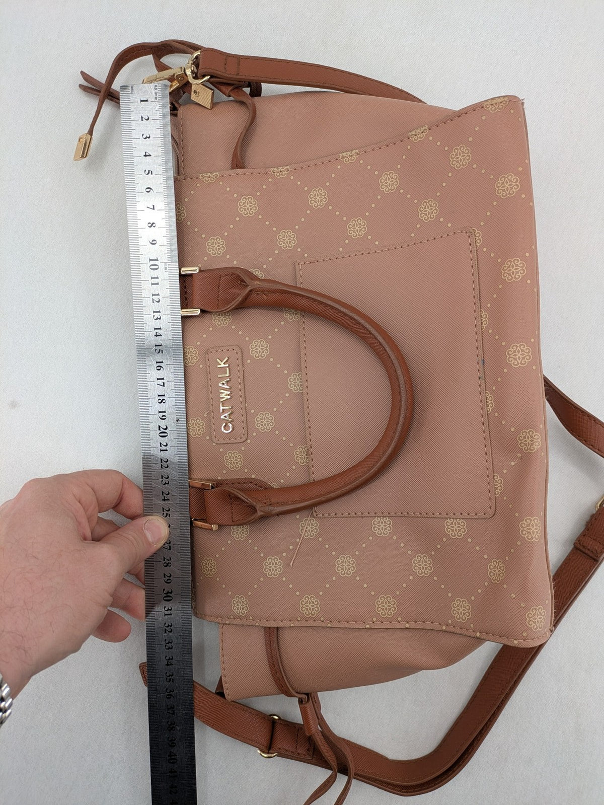 Catwalk gold handbag with pink and brown monogram pattern, adjustable shoulder strap.