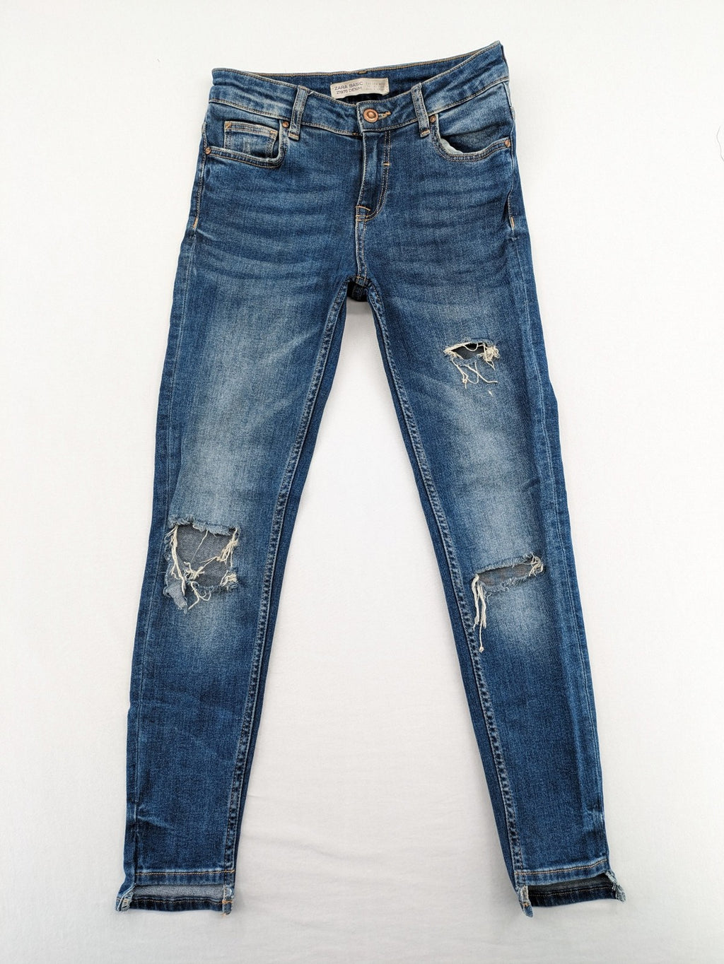 Zara Basic blue skinny jeans with destroyed knee details and frayed hem.