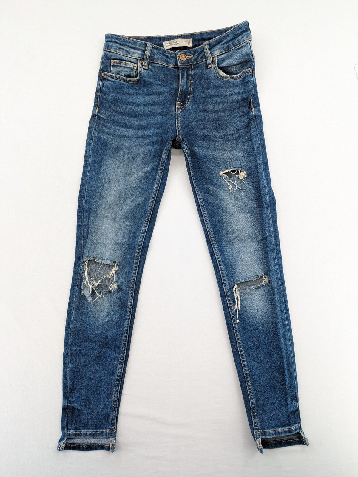 Zara Basic blue skinny jeans with destroyed knee details and frayed hem.