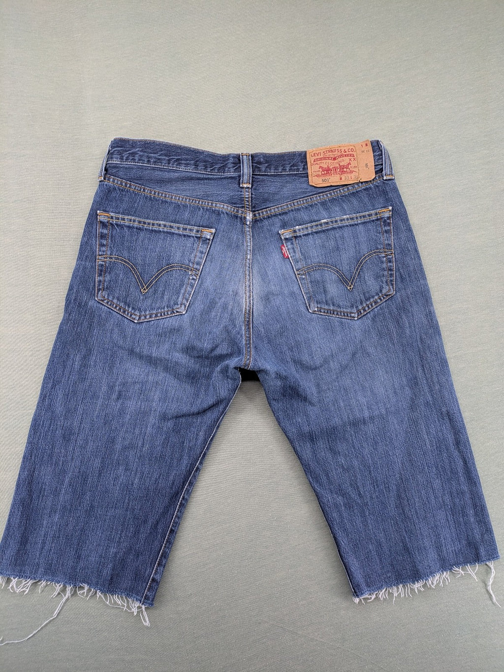 Levi's blue cut-off shorts with frayed hem, classic 5-pocket design, button fly.