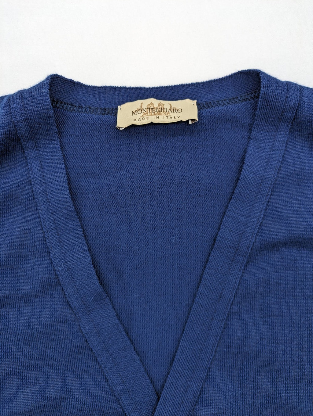 Montechiaro blue turtle neck jumper with V-neck, button placket, and sleeveless design.