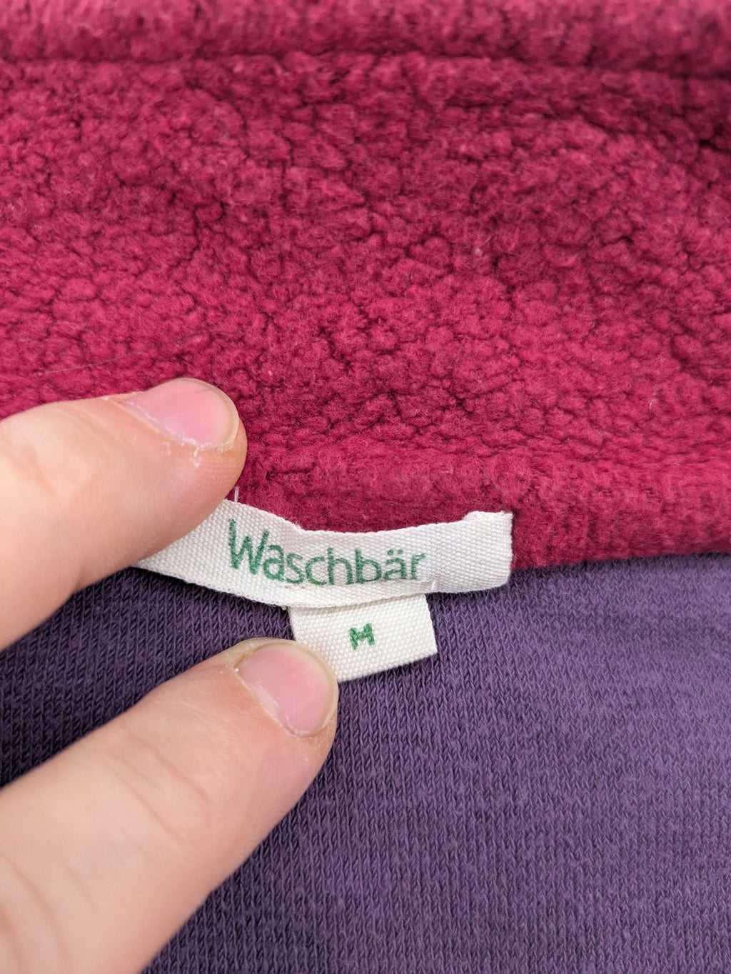 Waschbär pink and purple fleece jacket with red contrast details and high collar.