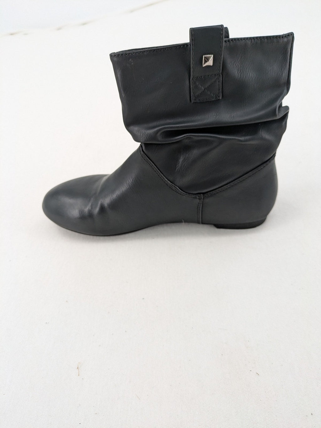 DAF black booties with decorative strap and studded details, made of faux leather.