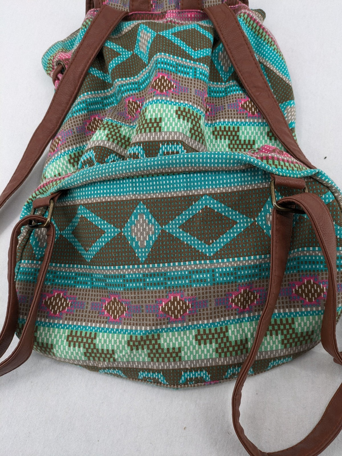 Boho multi backpack with vibrant Aztec tribal print and brown faux leather accents.